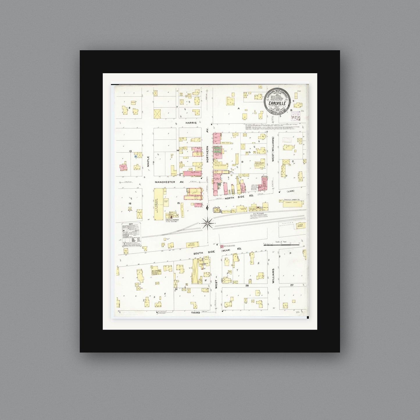 Historic Sanborn map print displayed in a thick black gallery frame on a dark wall