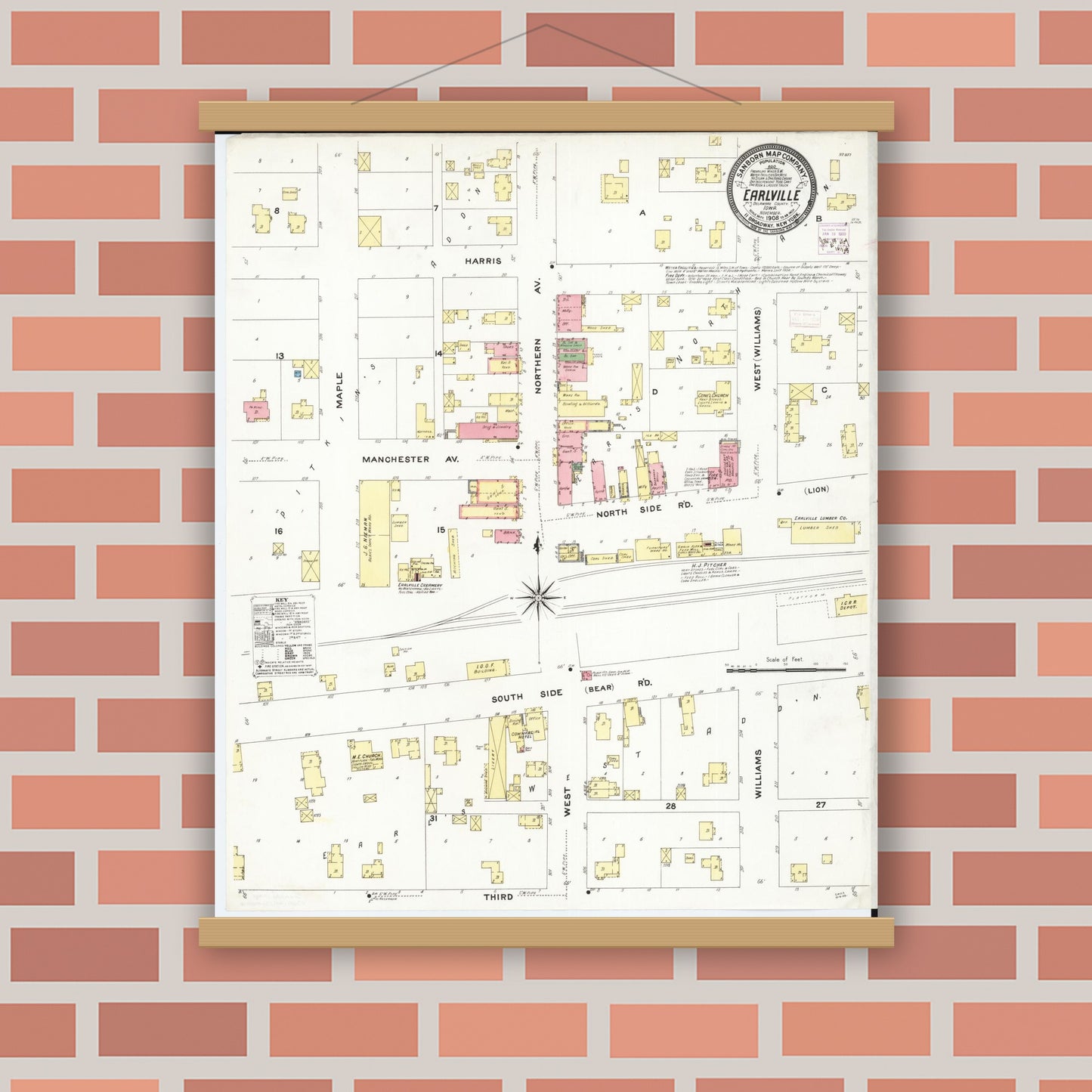 Historic Sanborn map print displayed in a magnetic wood poster frame on a red brick wall