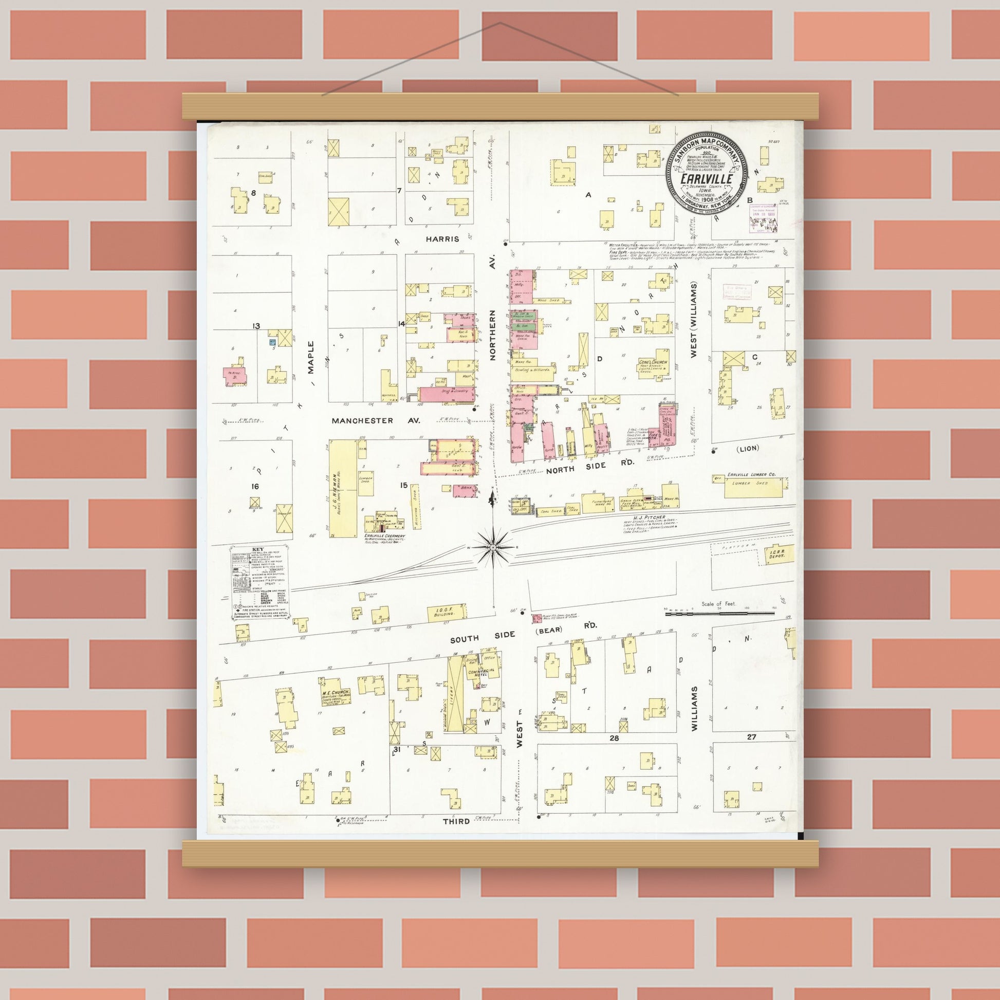Historic Sanborn map print displayed in a magnetic wood poster frame on a red brick wall